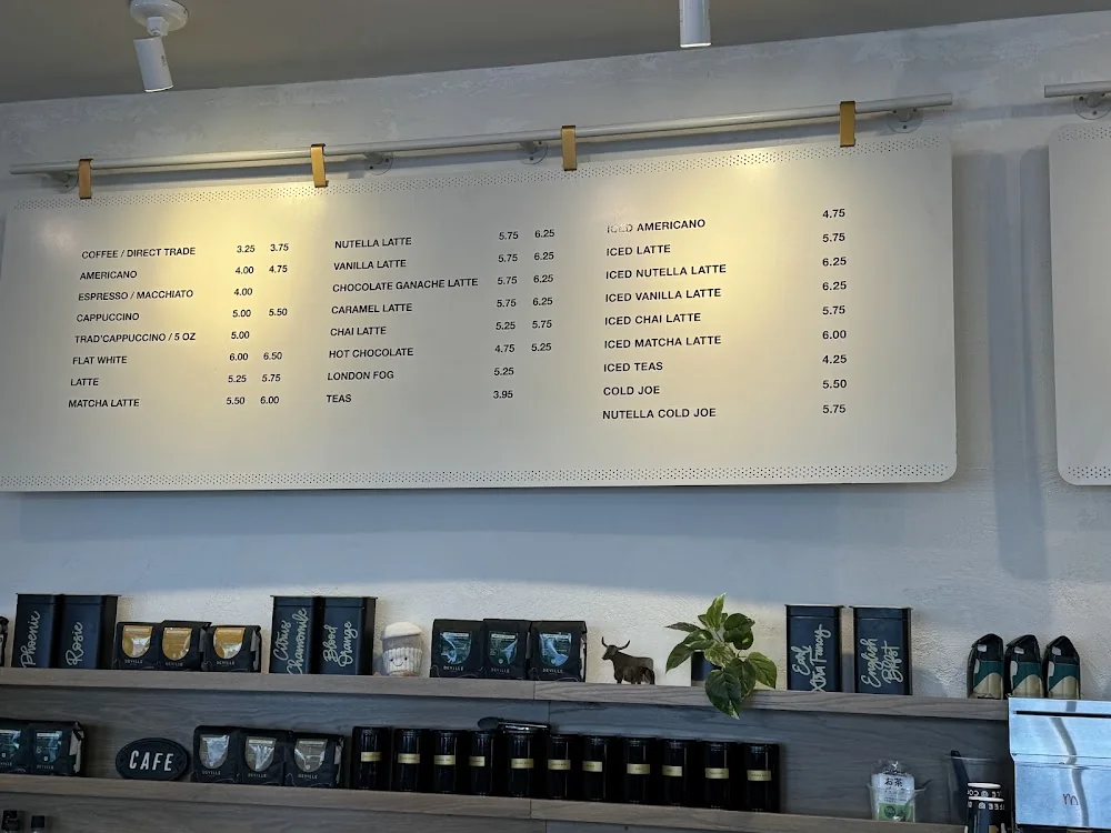 Deville Coffee menu board with drink prices: current in-store price card for lattes, iced drinks and hot beverages