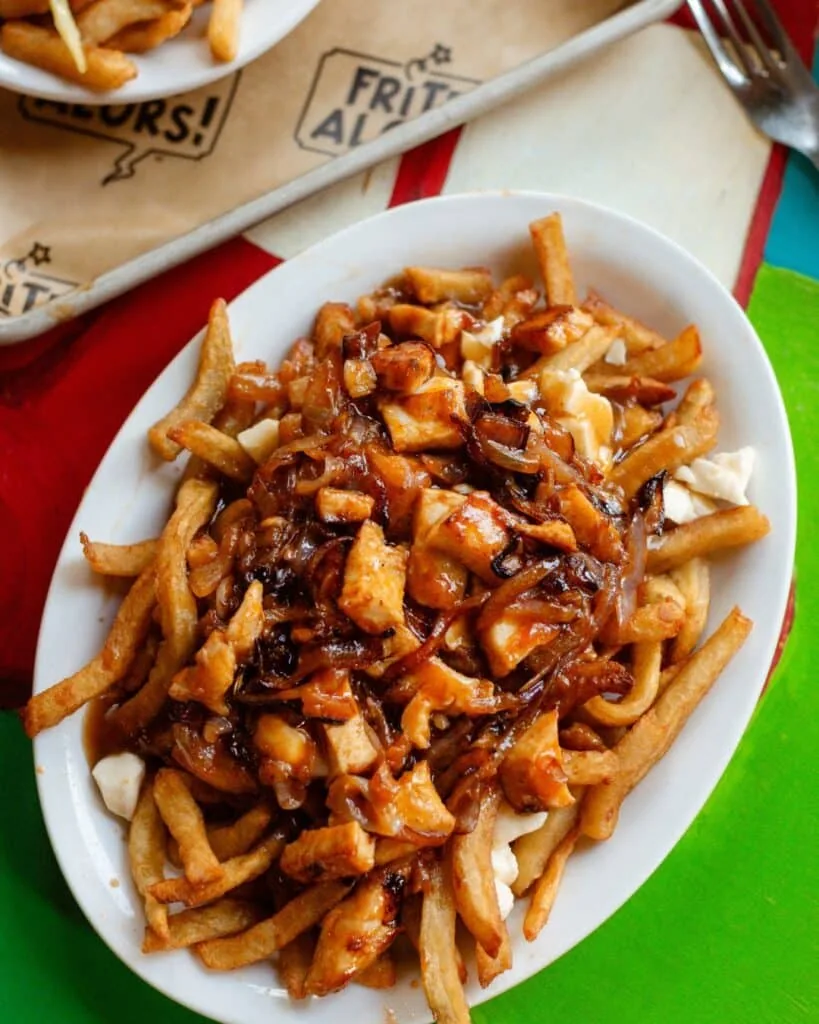 Frite Alors poutine with caramelized onions and melted cheese curds on a branded tray, frite alors menu prices canada